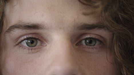 close up of man beautiful blue eyes opening caucasian male awake looking at camera watching iris focus