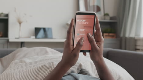 unrecognizable african-american woman using phone in bed