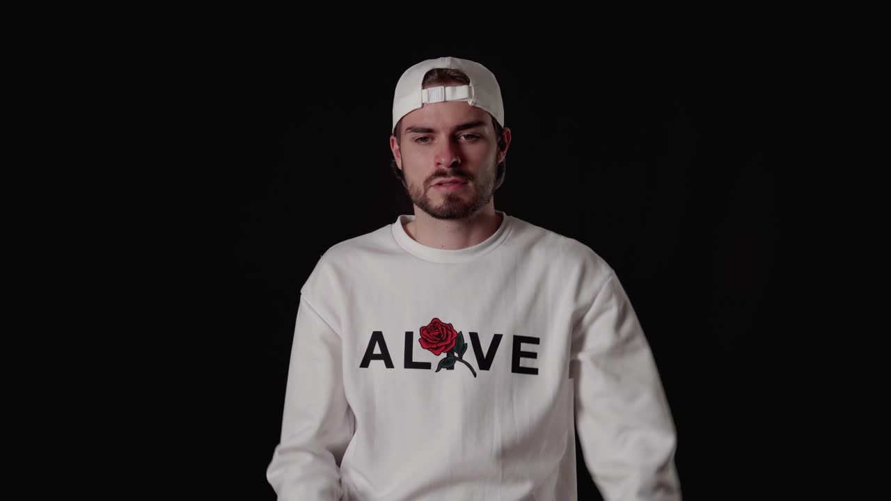 세련된 20대 남자가 극단적인 엄지손가락을 아래로 내리고, 비승인 제스처, 넓고 검은 배경