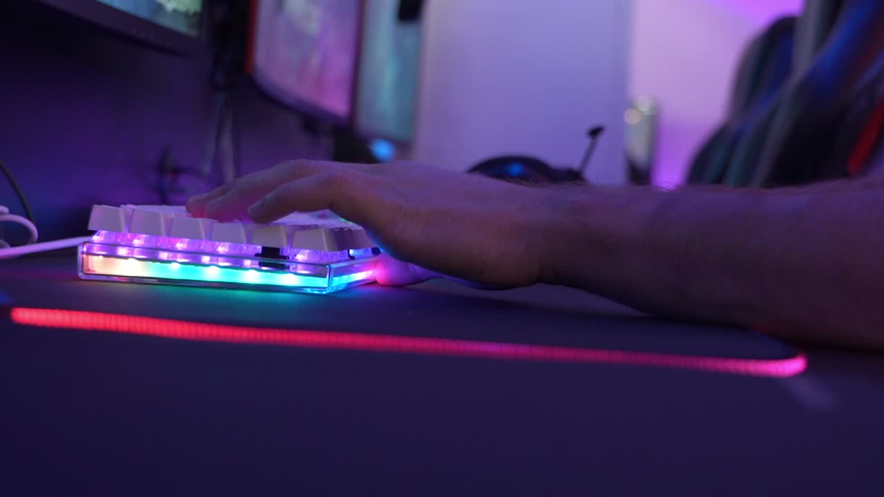 Man typing on a white keyboard while playing an online game