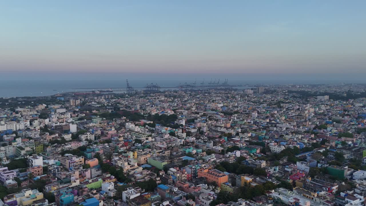 Drone footage capturing dense housing clusters near a sprawling railway yard