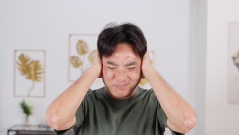 a man in a green shirt shows frustration in a well-lit room with decorative art