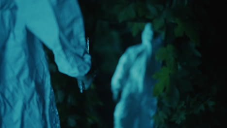 person in hazmat suit in dark forest
