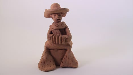 the musician plays the accordion. small ceramic sculpture