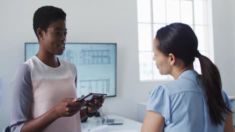 Two-diverse-businesswoman-working-and-talking-in-office