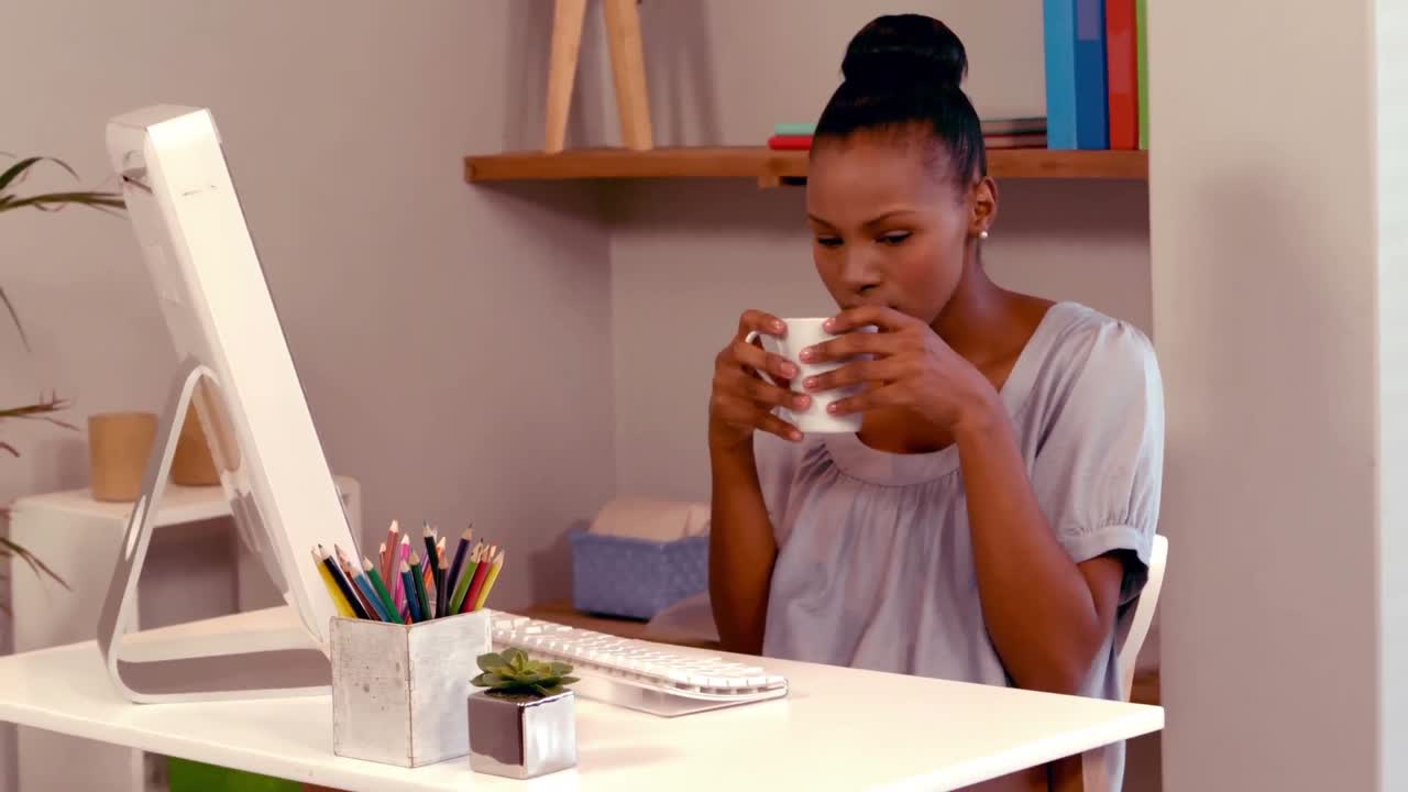 mujer usando computadora y bebiendo café