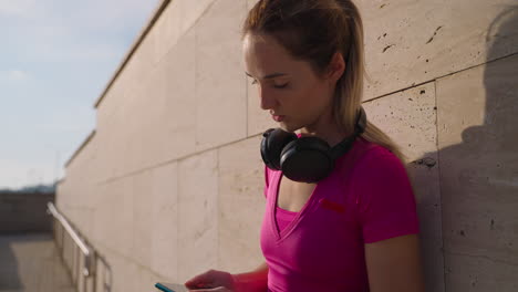 mujer comprobando el teléfono mientras descansa afuera