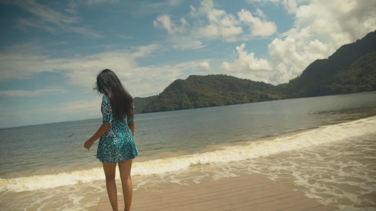 멋진 풍경을 배경으로 포즈를 취하고 바람이 부는 동안 머리카락으로 돈을 지불하는 아름다운 모델