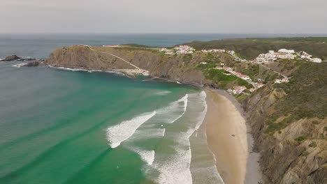 aerial shot flying high over a beautiful ocean bay with waves of turquoise water crashing on the beach