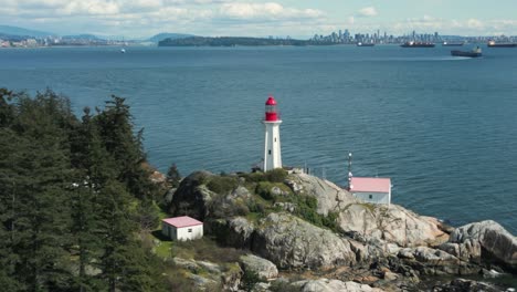 Vista-Aérea-Del-Faro-De-Point-Atkinson-En-El-Parque-Del-Faro-En-El-Oeste-De-Vancouver-Con-La-Ciudad-De-Vancouver-Al-Fondo,-Columbia-Británica,-Canadá