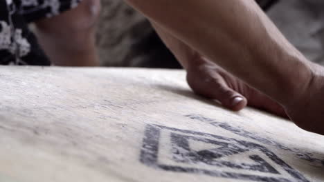 surfer waxing his surfboard - hand applying wax on surfing board