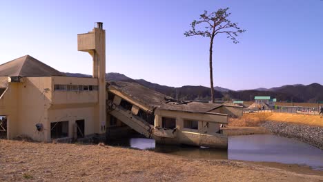 turistas que miran el edificio destruido en el museo conmemorativo del tsunami de iwate