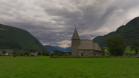 Distinctive-Hove-stone-church-in-Vikoyri,-Norway-under-ominous-overcast-sky