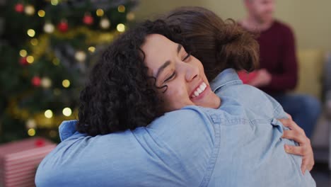 felices amigos masculinos y femeninos diversos abrazándose en la época de navidad