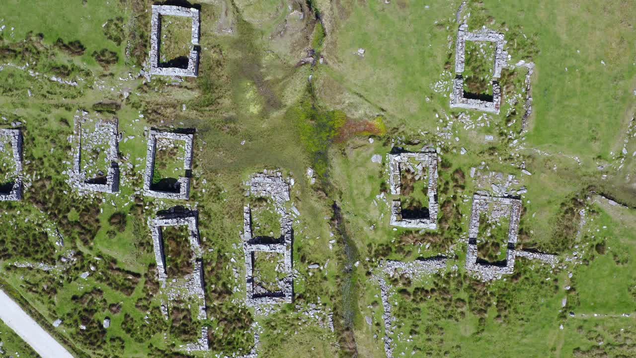 Desereted historic village rock wall ruins of slievemore achill island, ireland, top down aerial descending