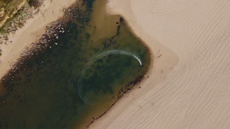 overhead shot of rc boat speeding on foz do lizandro beach, portugal