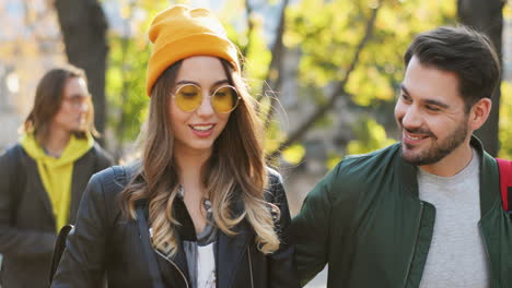 young caucasian friends walking and talking on a nice sunny day in the park in autumn