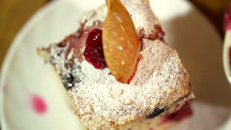 isolated close-up view of adding tasty delicious toppings of cherries on a slice of cake