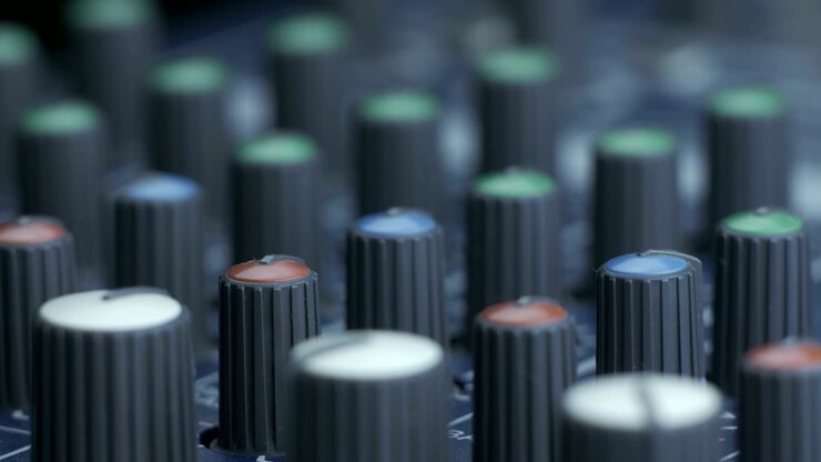 Dita femminili che girano le manopole dell'equalizzatore su un mixer