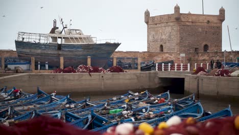 fishing boats all gathered in port area with fortress standing above