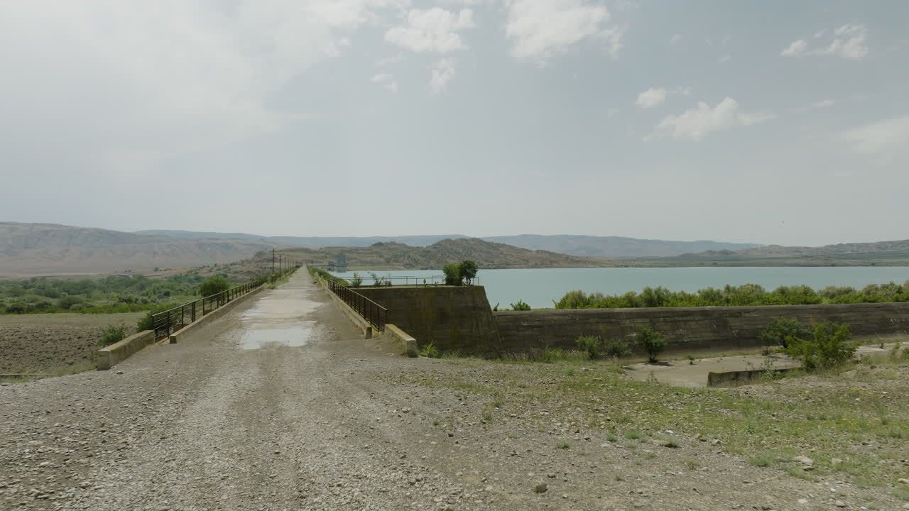 puente y carretera asfaltada en la pared del dique de la presa del embalse de dali mta, georgia