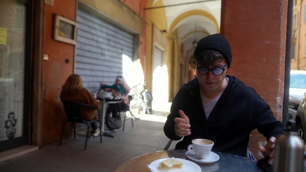 Person enjoying coffee and pastry in an outdoor cafe in Italy
