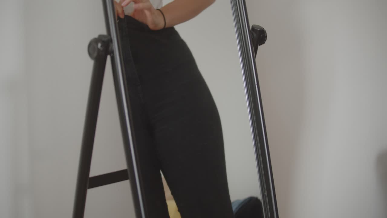 거울 앞에서 청바지를 입은 여자