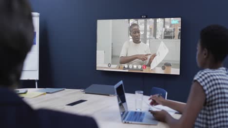 diversas personas de negocios en videollamada con una colega afroamericana en la pantalla