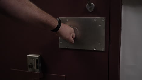 Prison-guard-shuts-and-locks-prisoner-inside-prison-door-in-cinematic-slow-motion