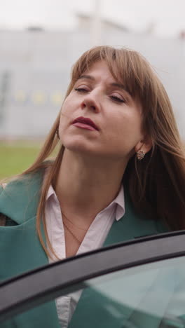 curious woman got out of car looking upward at big office building. elegant business lady closes door of automobile going away closeup slow motion