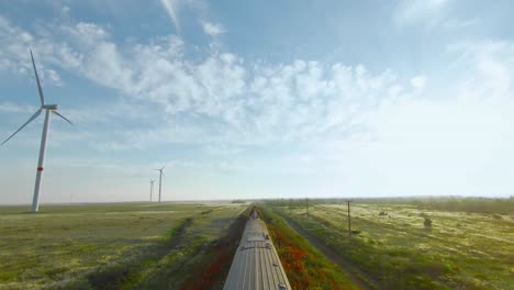 train journey through a scenic landscape with wind turbines