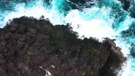 Olas-Con-Espuma-Rompiendo-En-Los-Escarpados-Acantilados-En-El-Mirador-De-Ponta-Do-Querão,-Isla-Terceira,-Azores---Antena-De-Arriba-Hacia-Abajo