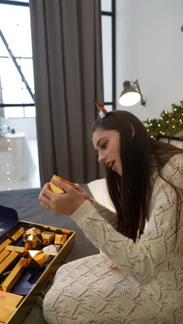 una mujer joven examinando los regalos del calendario de adviento de navidad