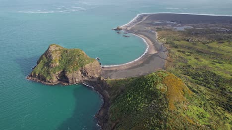 la playa de whatipu entre la isla de paratutae y ninepin rock en la bahía de wonga wonga en auckland, nueva zelanda