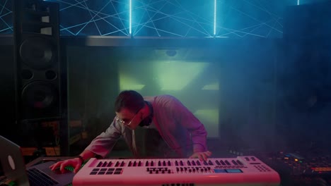 el joven dj mezcla profesionalmente canciones de fiesta en el escenario del club.