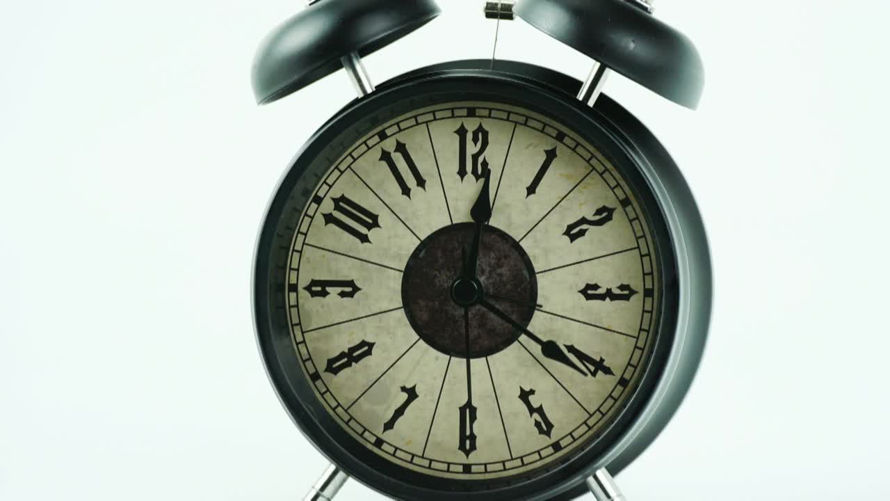 Time lapse black alarm clock tell the time 12:37 minute.