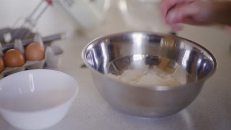 close-up of chef's hand moving flour with hand preparing dough