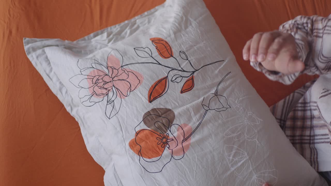 Person Examining a Decorative Pillow