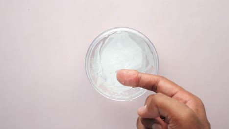 tocando con la mano el gel transparente en un cuenco