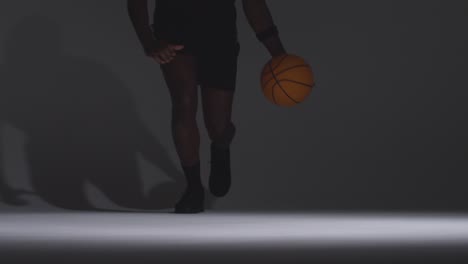 Close-Up-Front-View-Studio-Shot-Of-Male-Basketball-Player-Running-Jumping-And-Shooting-Ball-At-Basket