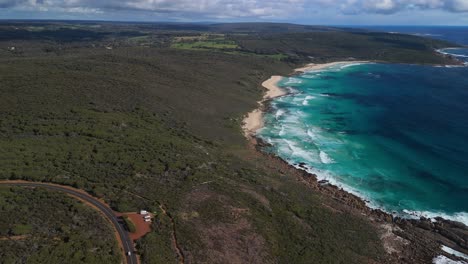 drone rising above smith beach in margaret river, western australia