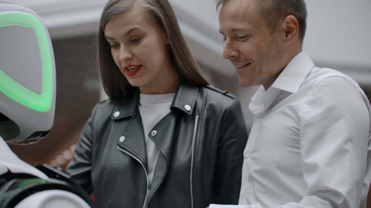 современные робототехнические технологии взаимодействия с людьми. дружба и общение пар с роботом. помощник будущего. робот смотрит в камеру на человека. робот проявляет эмоции. поднимает руки, танцует или является независимым.