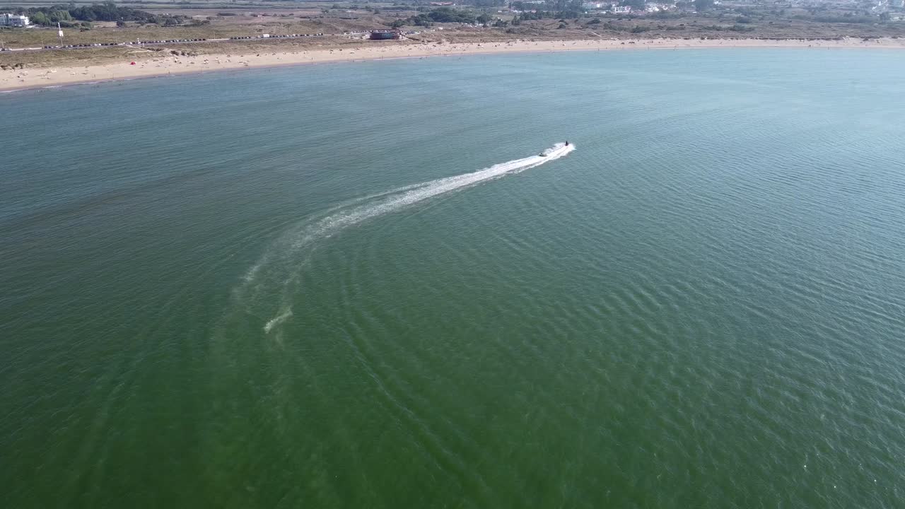 Aerial View of Jet Ski Towing Inner Tube of Coast in São Martinho do Porto, Portugal