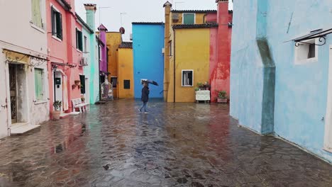 woman walking colourful street with umbrella avoiding wet rain puddles