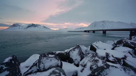 Los-Bancos-Nevados-Se-Ven-En-La-Península-De-Snaefellsne-En-Islandia-Al-Atardecer-Con-Pájaros-Nadando-En-El-Agua-1