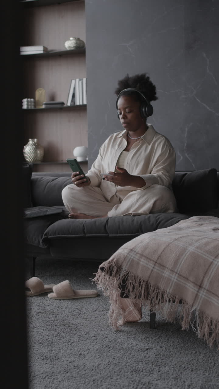 Woman Relaxing at Home with Headphones and Smartphone