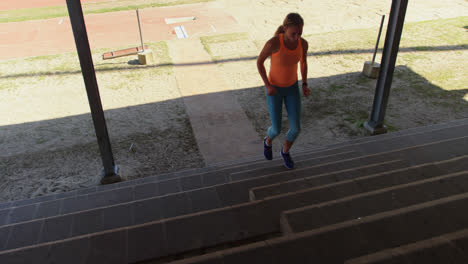 front view of caucasian female athlete exercising on steps at sports venue 4k