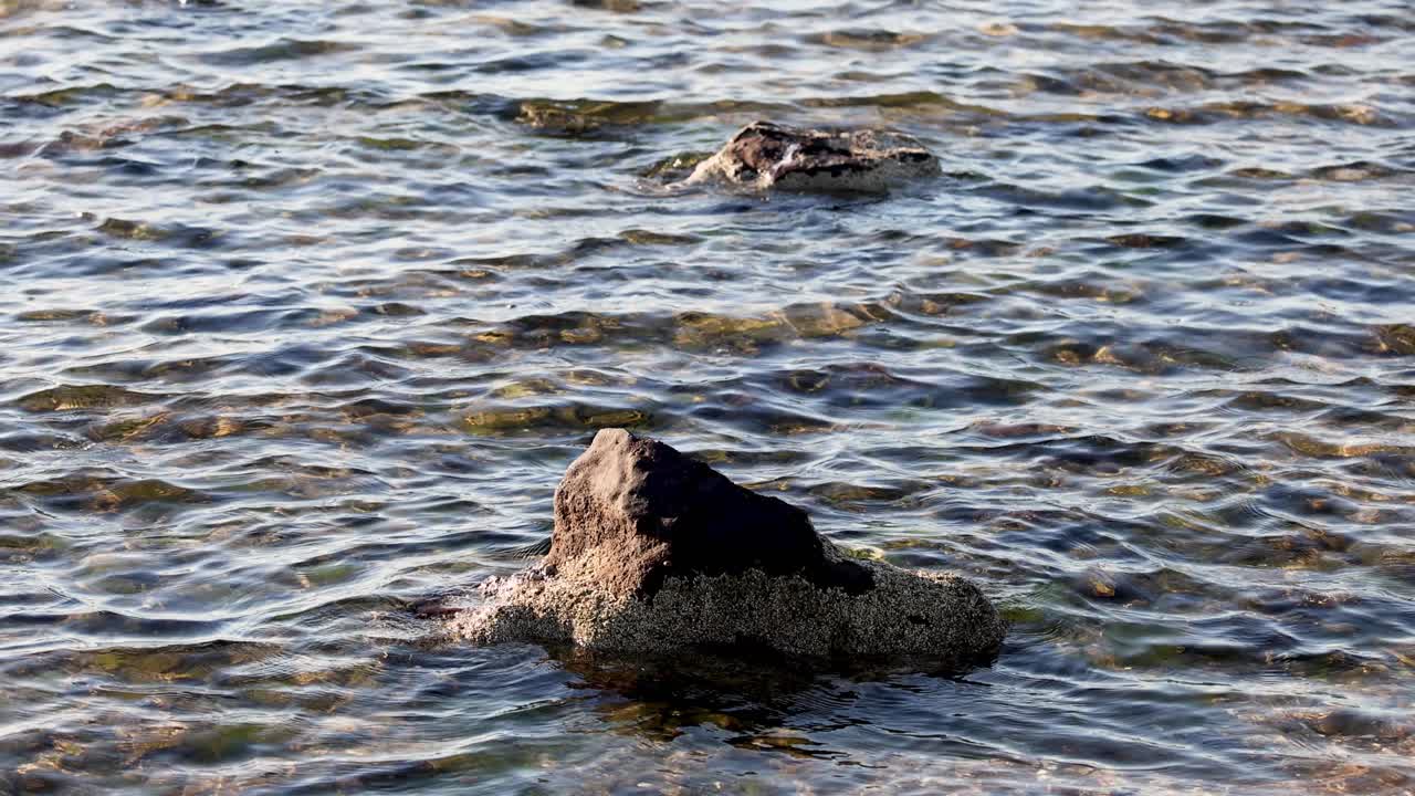 Onde si infrangono dolcemente contro uno scoglio solitario