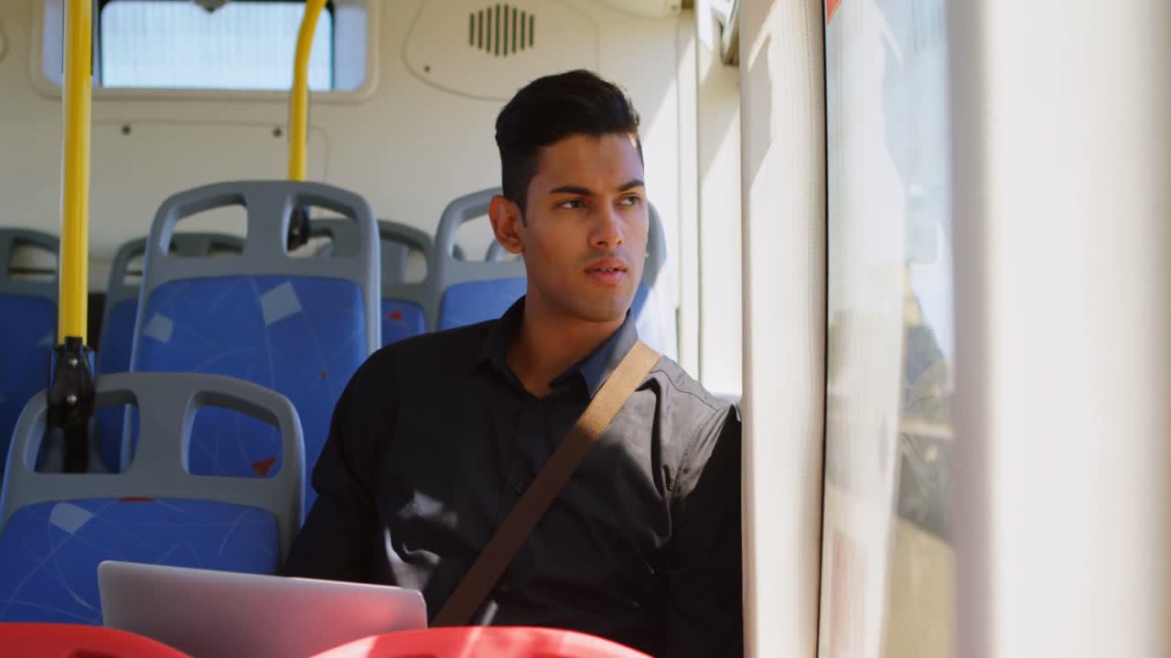 pasajero masculino que usa una computadora portátil mientras viaja en el autobús 4k