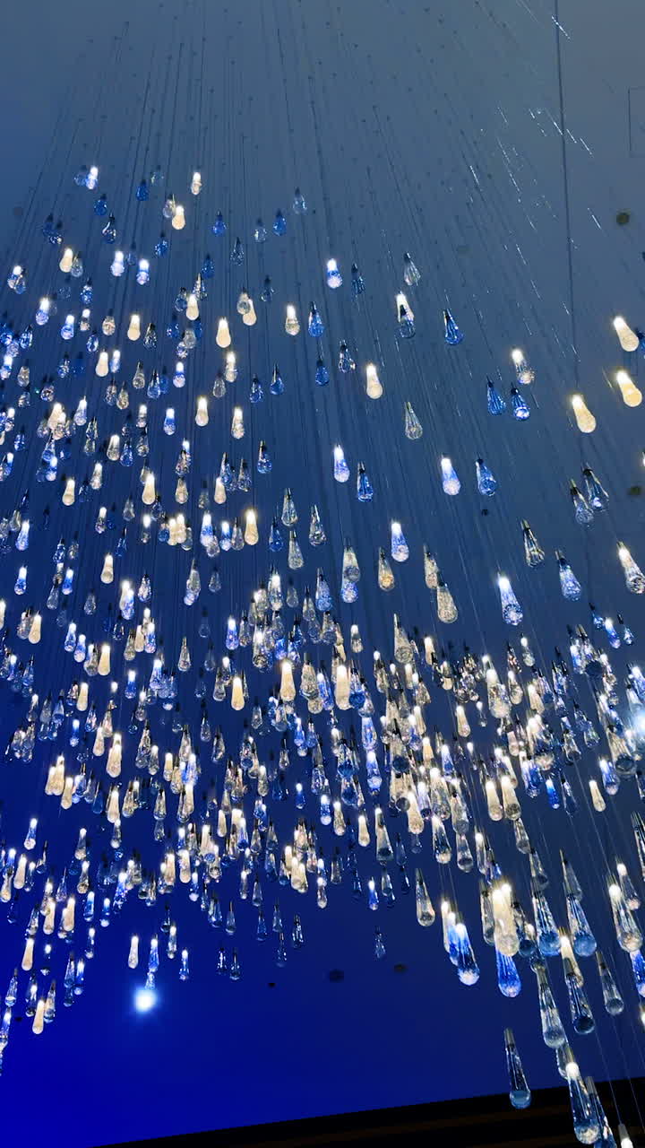 Chic chandelier with cascading lights. An intricate arrangement of lights hanging from the ceiling creates a stunning visual effect in a modern space